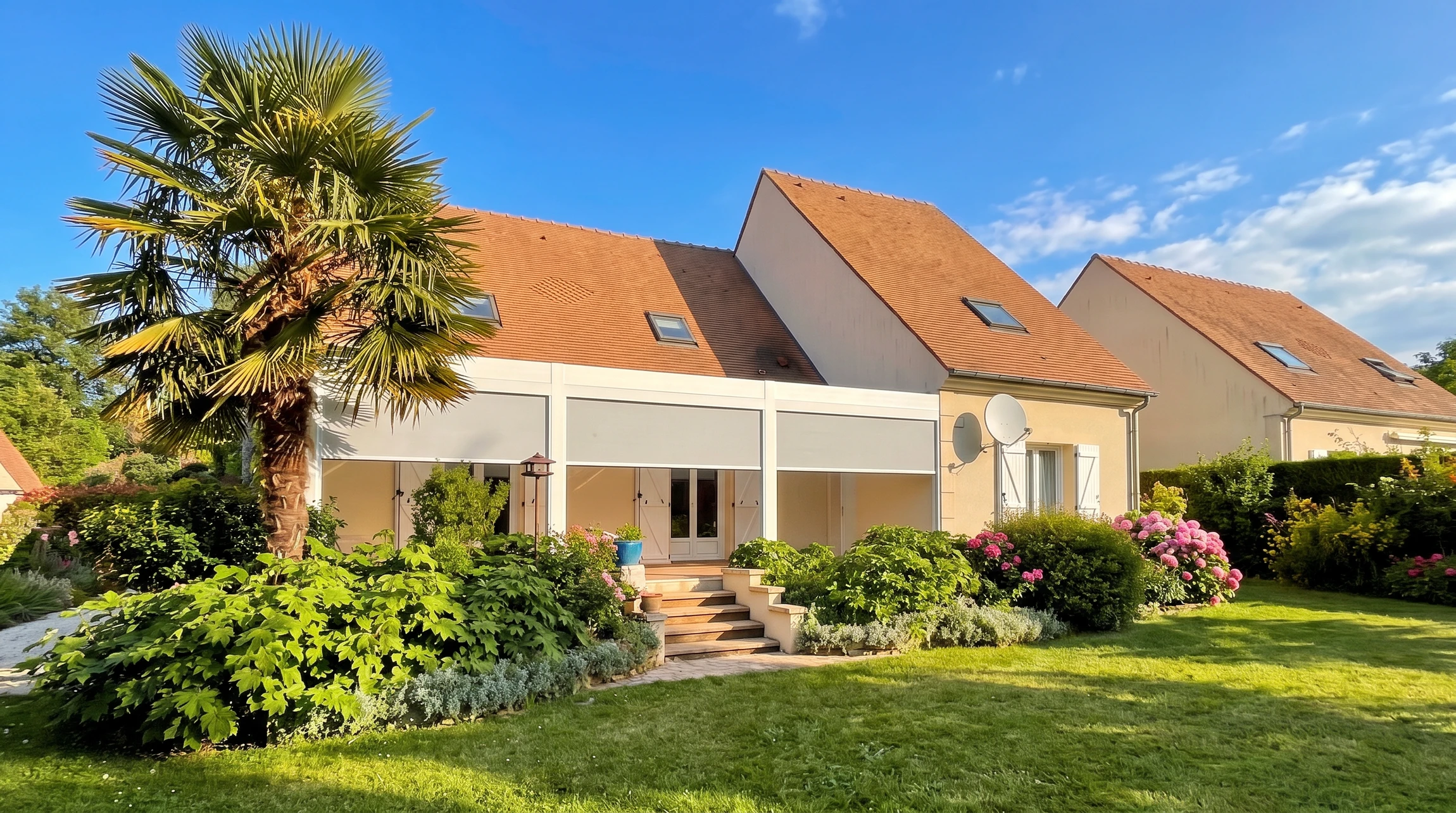 Maison contemporaine avec garage intégré, façade mixte crépi blanc et bardage gris anthracite