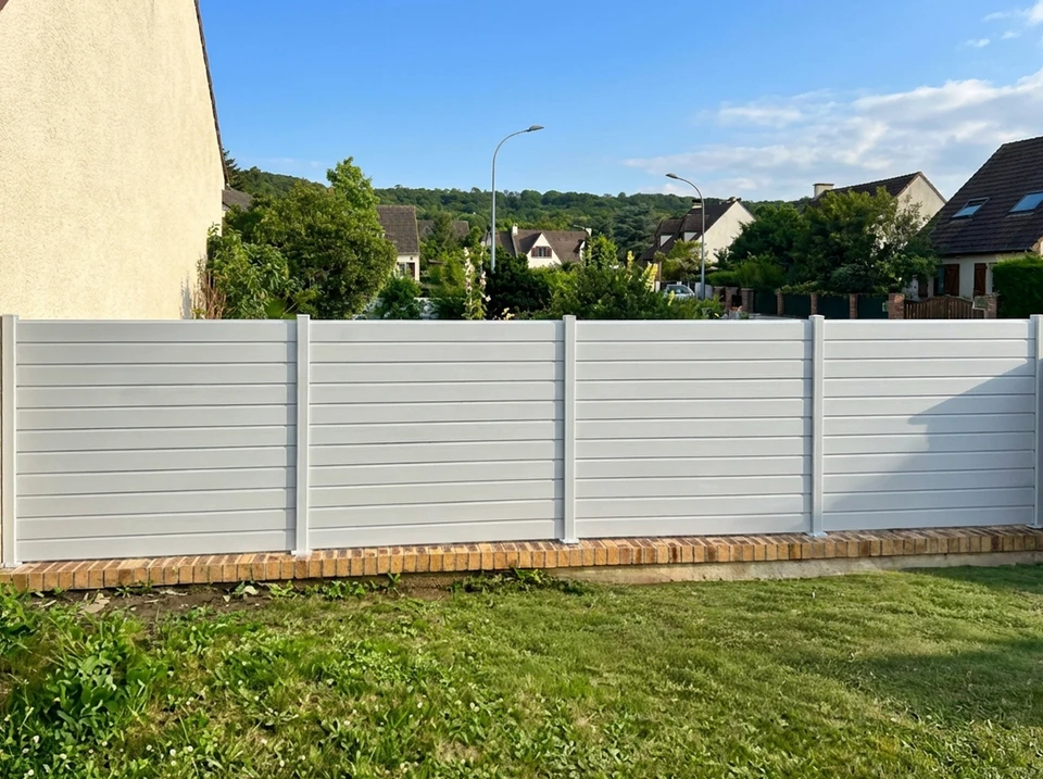 Façade extérieure en enduit grésé beige avec volets battants fermés en aluminium gris anthracite, style lisse à lames horizontales