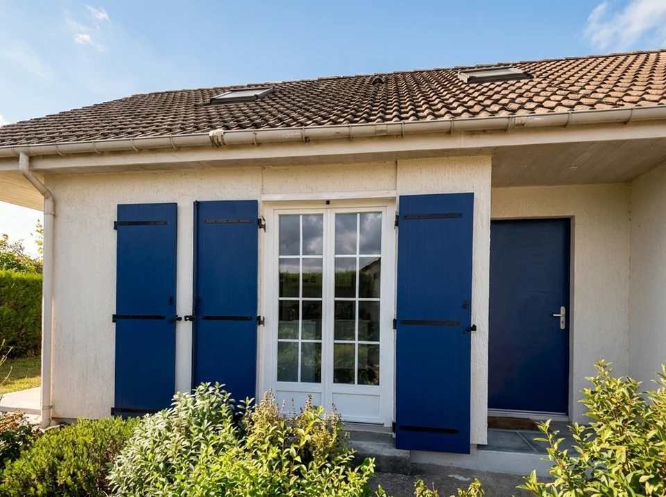 Pièce lumineuse avec fenêtre double vantail PVC blanc à petits bois intégrés, 6 carreaux par vantail, donnant sur jardin verdoyant