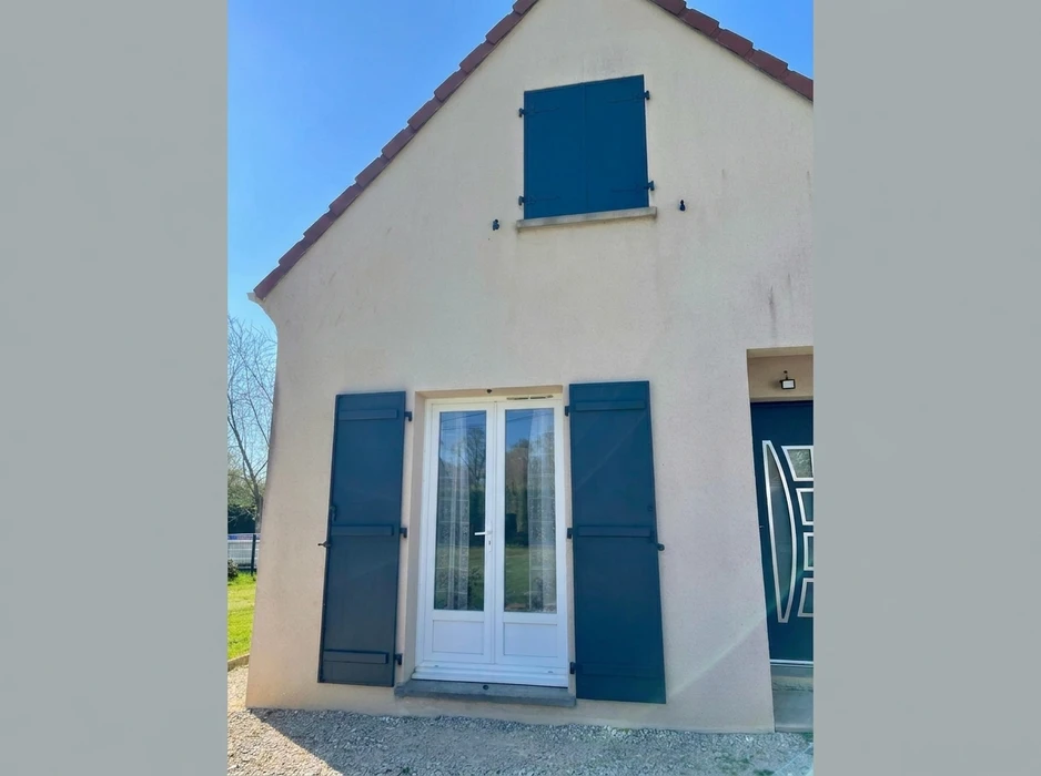 Façade extérieure en enduit grésé beige avec volets battants fermés en aluminium gris anthracite, style lisse à lames horizontales