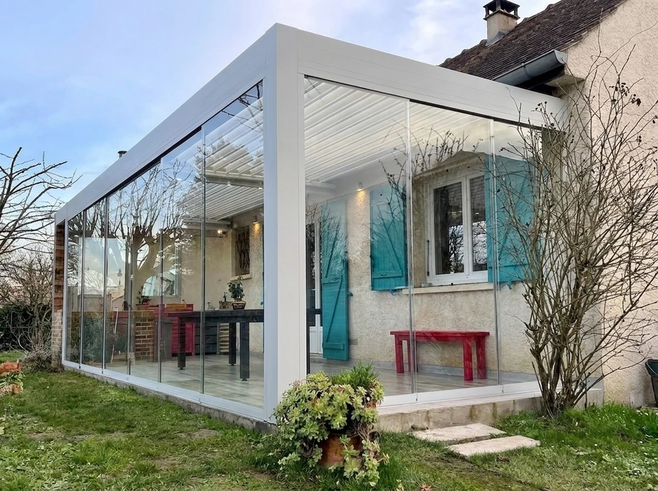Pergola bioclimatique aluminium anthracite installée en terrasse attenante à une maison pavillonnaire